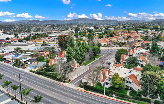 Aerial view of a residential and commercial area with roads and buildings.