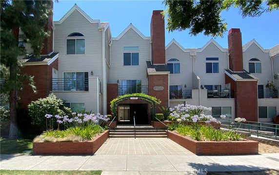 Front view of a multi-story residential building with brick and siding exterior.