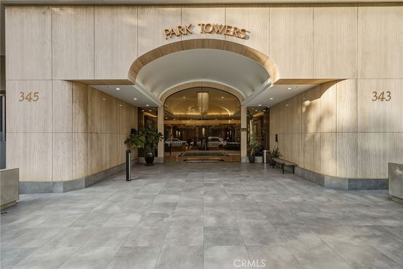 Entrance of a building named Park Towers with an arched passageway and tiled flooring.