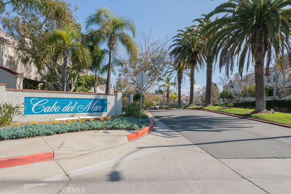 Entrance view with palm trees and a sign displaying 'Cabo del Mar'.