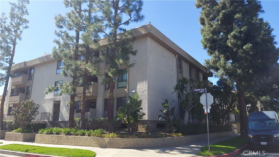 Corner view of a multi-story residential building with balconies.