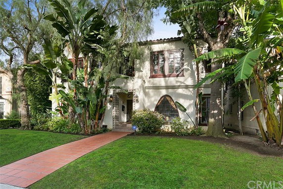 Front view of a two-story house with large windows and a tiled pathway.
