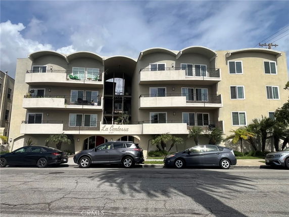 Front view of a multi-story apartment building with balconies.