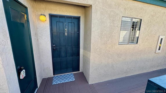 Front view of a building entrance with a door and external wall light.