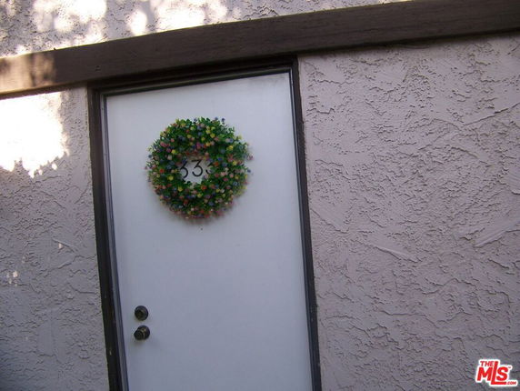Front view of a door with a floral wreath and the number 33 on it.