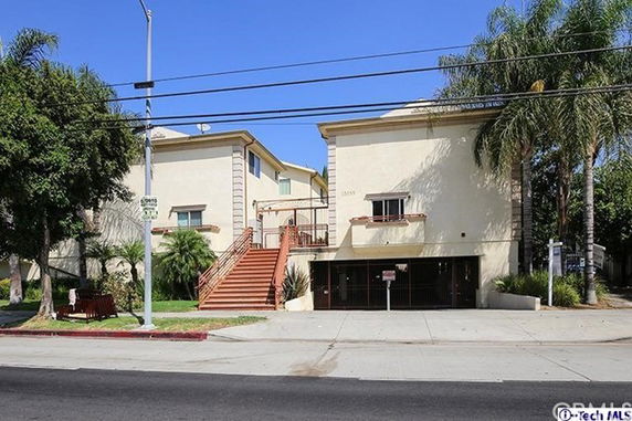 Front view of a multi-story building with stairs leading to the entrance.