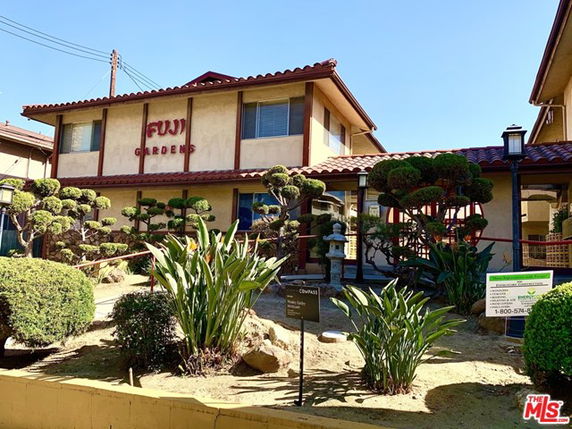 Front view of a two-story building with a sign reading 'Fuji Gardens' and manicured landscaping.