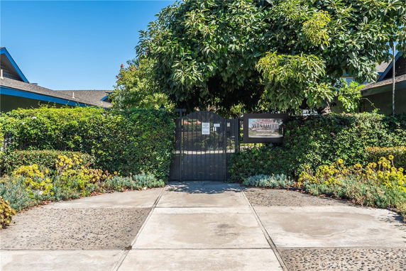 Front view of a building with a gated entrance surrounded by greenery.