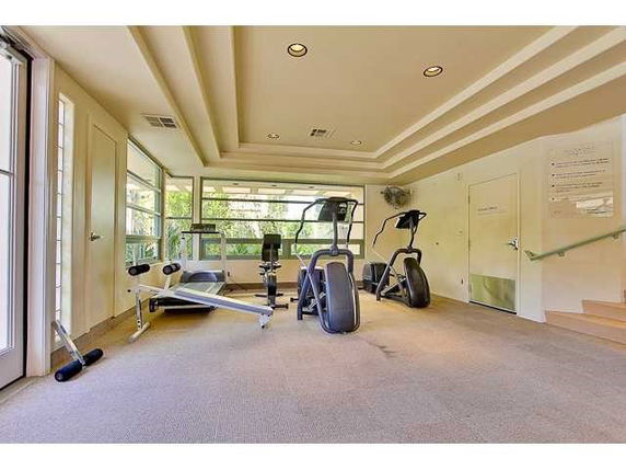 Indoor gym area with exercise equipment including treadmills and weight machines.