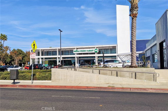 Front view of a modern store building with large glass windows and a parking area.
