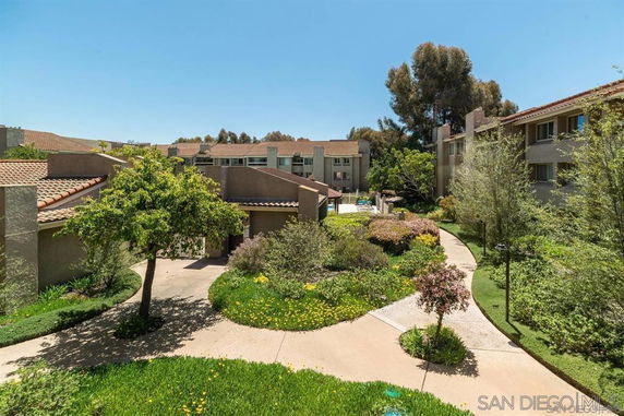View of multiple residential buildings with pathways and landscaped gardens.