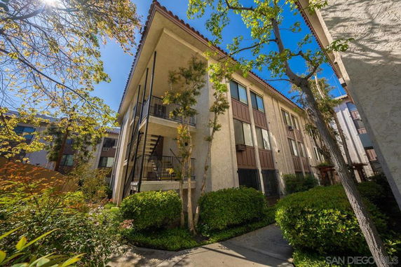 Front view of a multi-story residential building with balconies and external staircases.