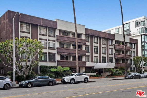 Front view of a multi-story building with balconies and an entrance canopy.