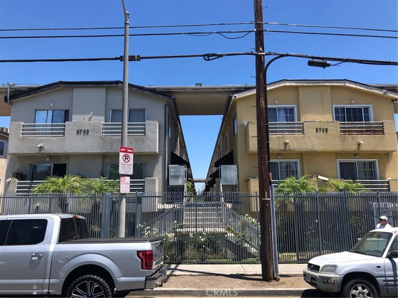 Front view of two adjacent apartment buildings with balconies and staircases.