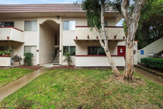 Front view of a two-story residential building with a textured exterior and central staircase.