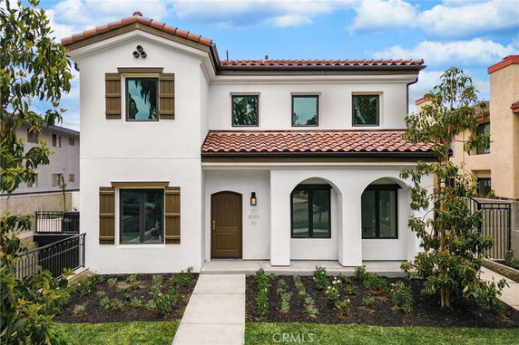 Front view of a two-story house with a tiled roof and wooden shutters.