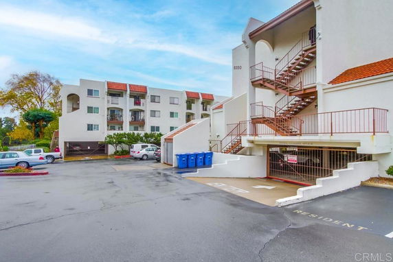Exterior view of a residential building with a parking area and a staircase.
