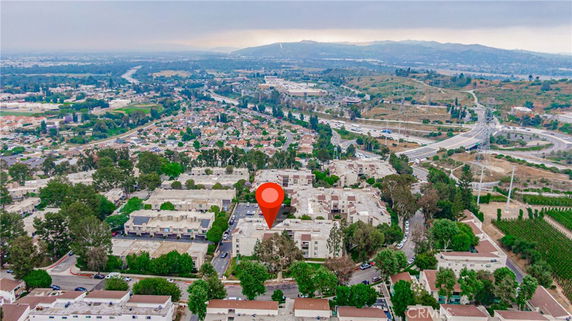 Wide angle aerial view of a residential area with multiple buildings and surrounding landscape.