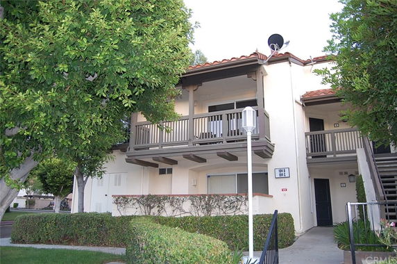 Front view of a two-story residential building with an exterior staircase and balcony.