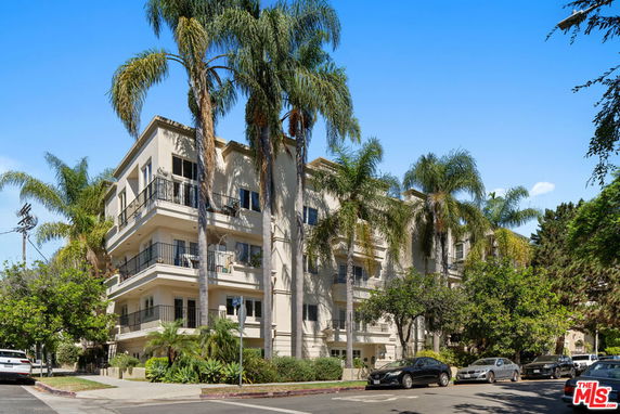 Front view of a multi-story apartment building with balconies.