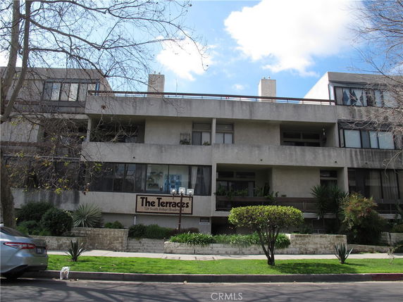 Front view of a multi-story residential building with balconies.