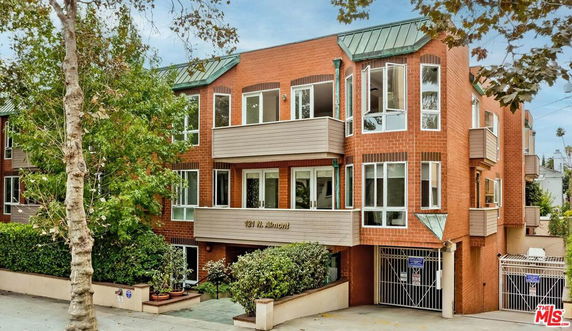 Front view of a multi-story brick building with large windows and balconies.
