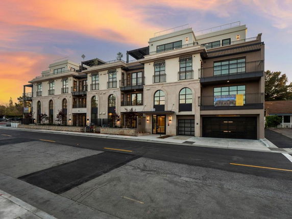 Front view of a multi-story building with large windows and balconies.