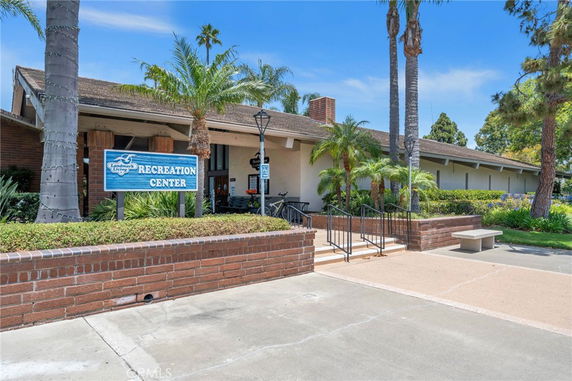Front view of a recreation center building with a brick facade and palm trees.