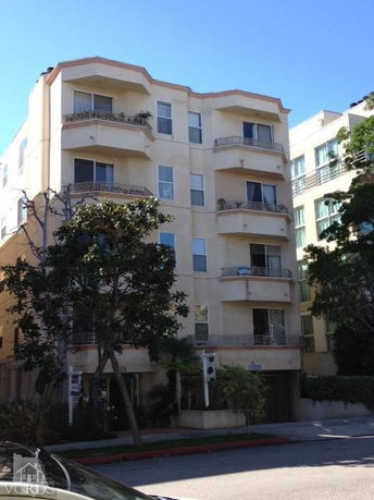 Front view of a multi-story residential building with balconies.