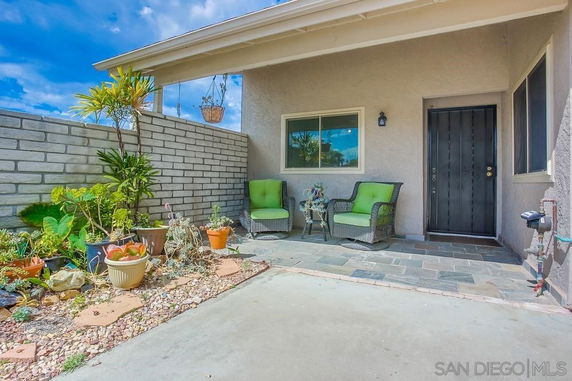 Front view of a house with a small patio area and plants.