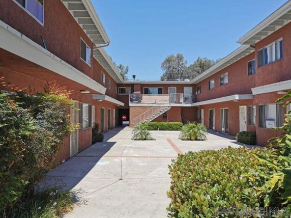 View of a two-story apartment building with an open courtyard and exterior stairway.