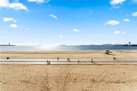 Panoramic view of a beach with a pathway and ocean in the background.