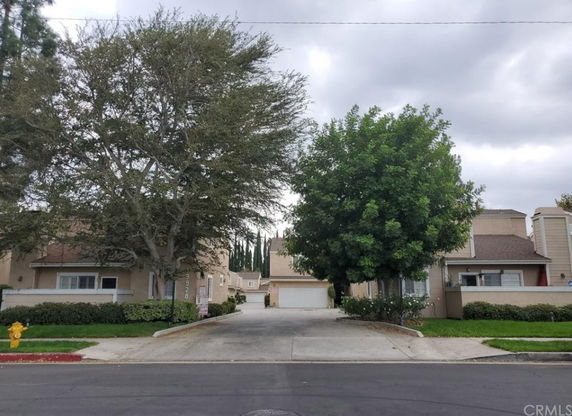 Front view of a two-story house with a driveway and trees.