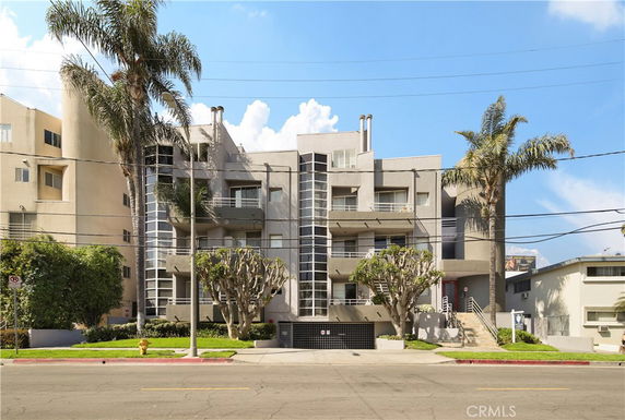 Front view of a multi-story apartment building with balconies.