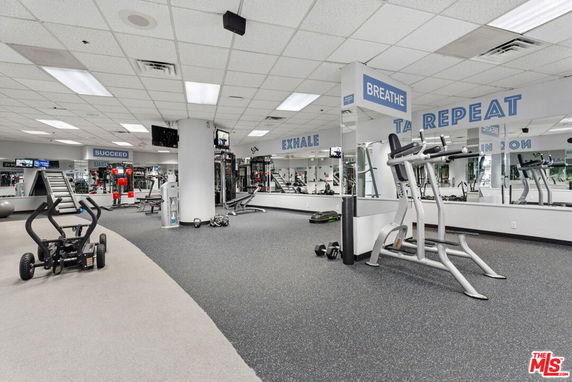 Interior view of a fitness gym with exercise equipment and motivational signage.