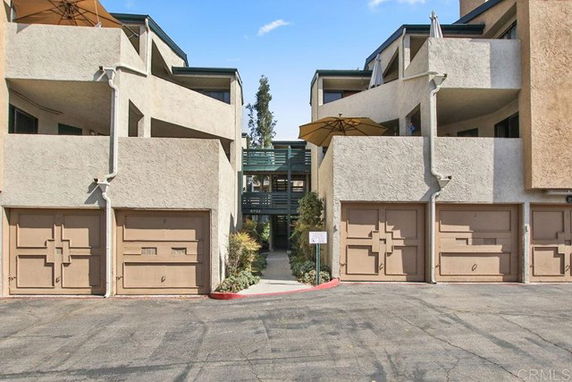 Front view of a multi-story building with garages and balconies.