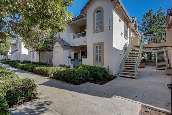 Front view of a two-story apartment building with stairs leading to the second floor.