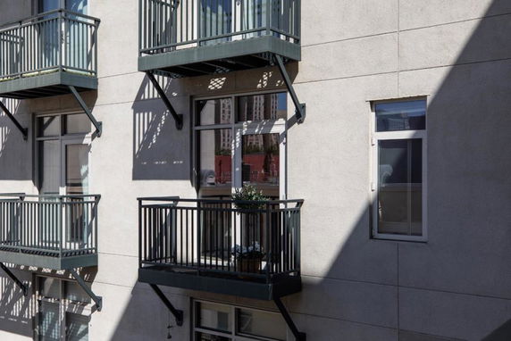Close-up view of an apartment building's exterior with balconies and windows.