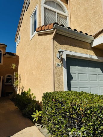 Front view of a two-story house with an arched window and a garage.