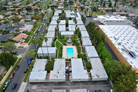 Aerial view of a residential complex with multiple rectangular buildings and a central swimming pool.