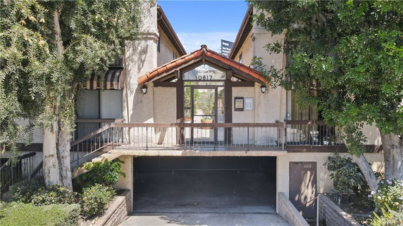 Front view of a residential building with an elevated entrance and sloped red-tile roof.