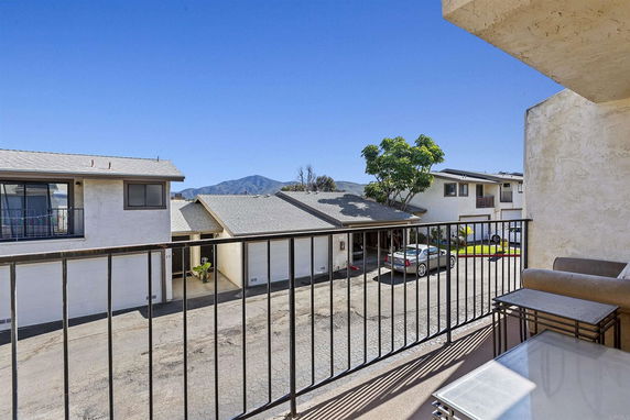 View from a balcony overlooking residential garages and a distant mountain.