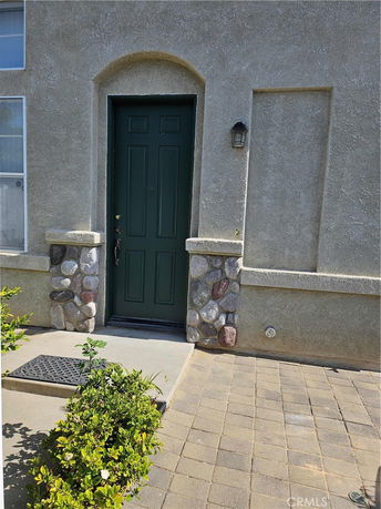 Front view of a house entrance with a dark green door and stone accents.