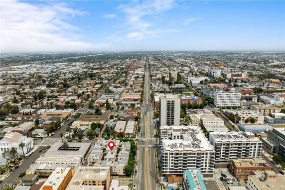 Aerial panoramic view of a cityscape with numerous buildings and streets.