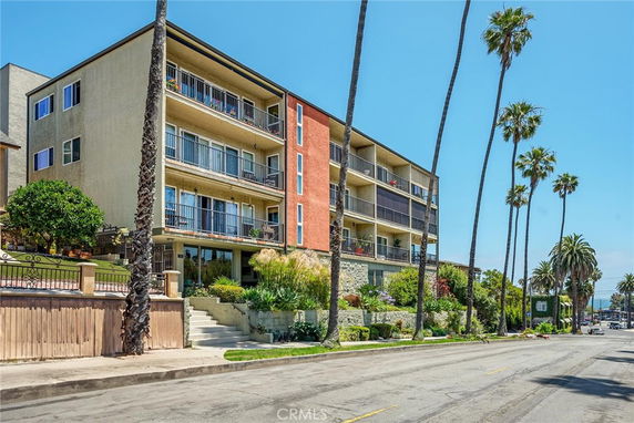Front view of a multi-story apartment building with balconies.