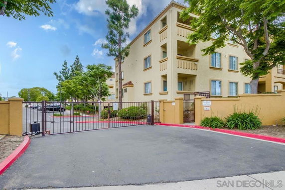 Front view of a multi-story residential building with gated entrance.