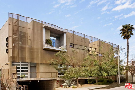 Front view of a modern multi-story building with a unique facade design.