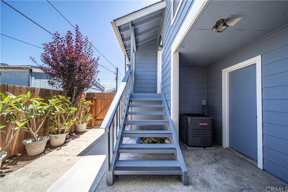 Exterior staircase and side view of a building with blue siding.