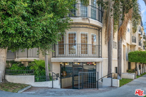 Front view of a multi-story building with large windows and a gated entrance.