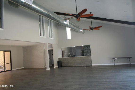 Spacious indoor area with ceiling fans and kitchenette, suitable for recreational activities.